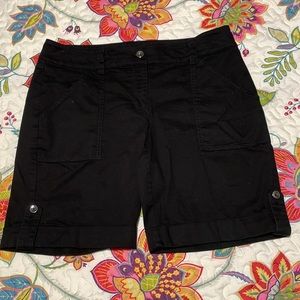 Black shorts. Button tab detailing at cuffed hem and back pockets.